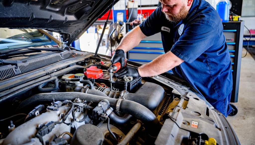 Mechanik pracuje na motoru vozu s otevřenou kapotou